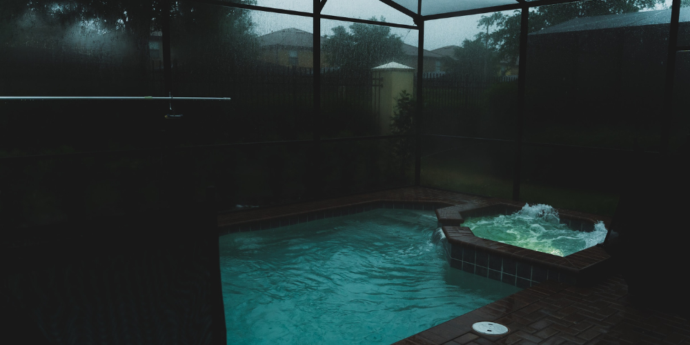 An enclosed hot tub and pool within a sunroom or conservatory
